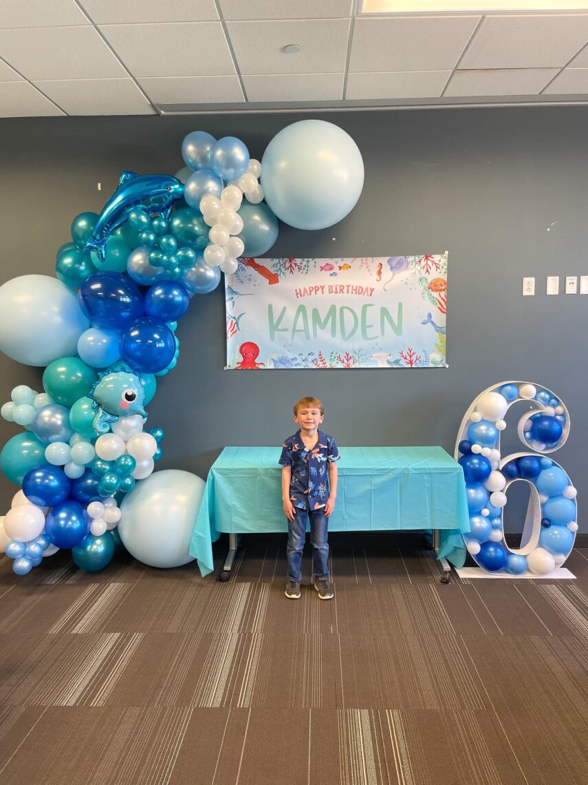 Large blue balloon garland and birthday sign. 