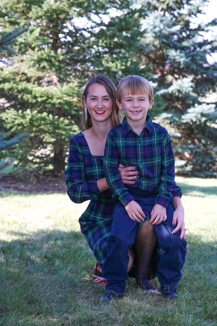 Young boy sitting on mom's lap smiling at the camera