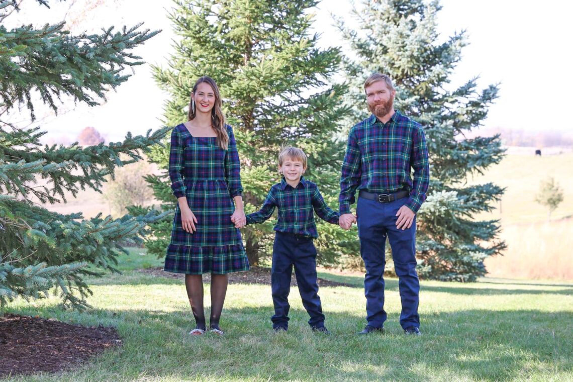 Family of three holding hands during during family photos