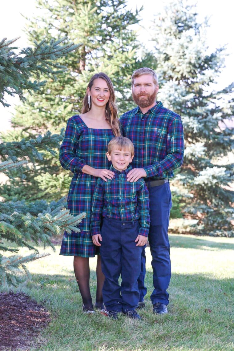 A family of three standing next to each other smiling for photos. 