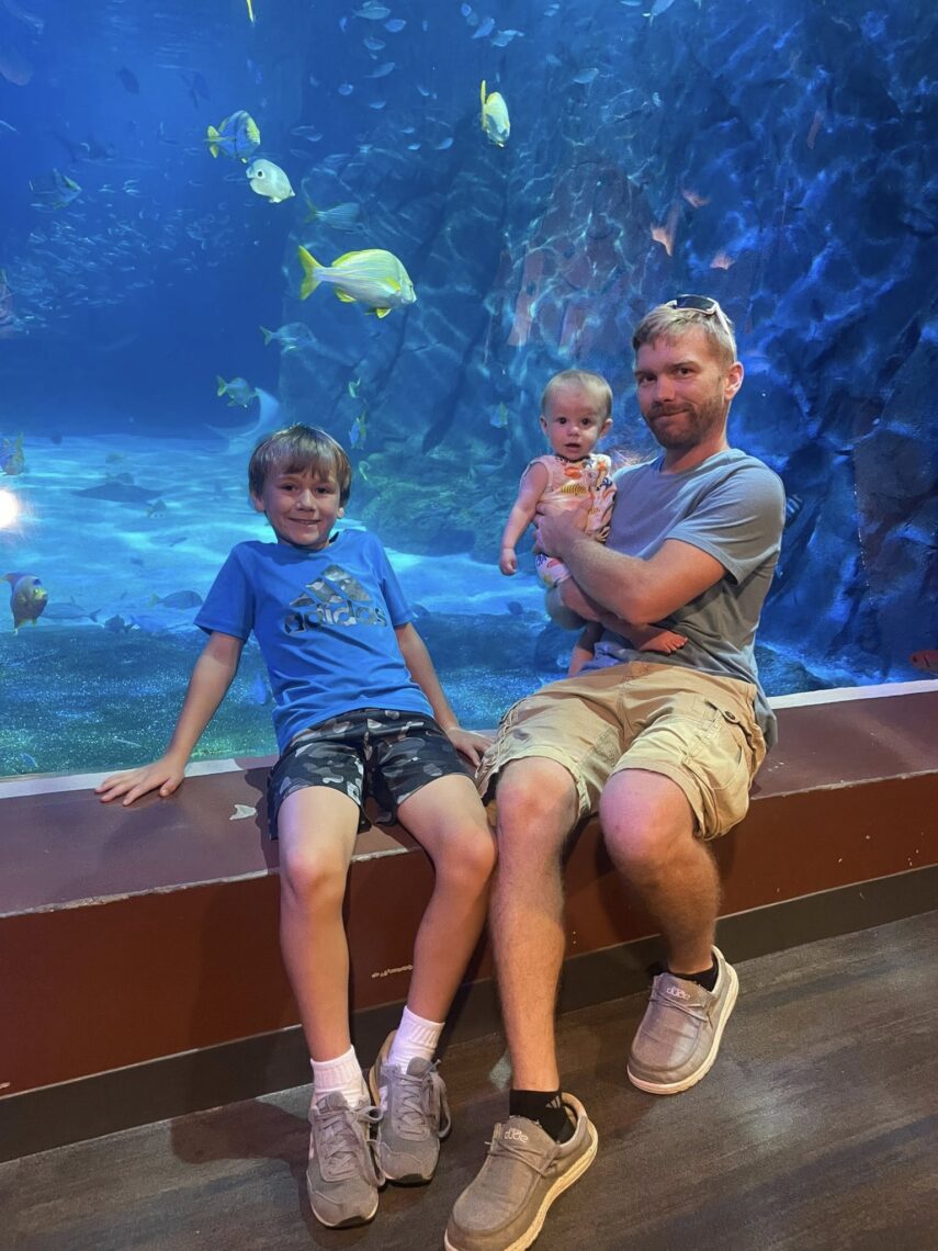 Father, son & daughter in front of large fish tank