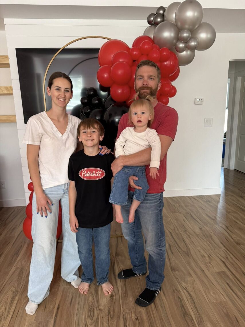 family photo in front of balloon garland